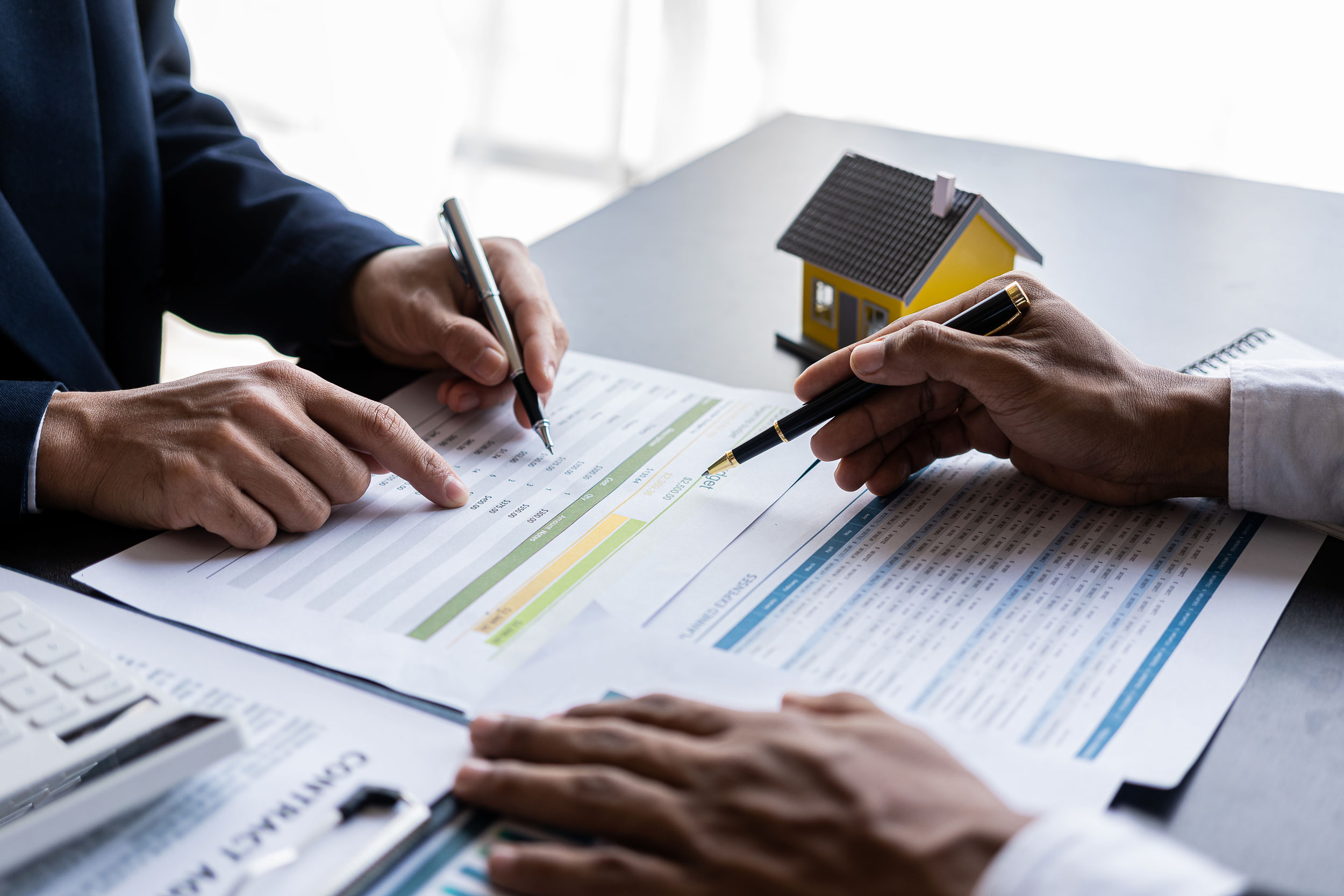 Two people reviewing budget + expenses documents