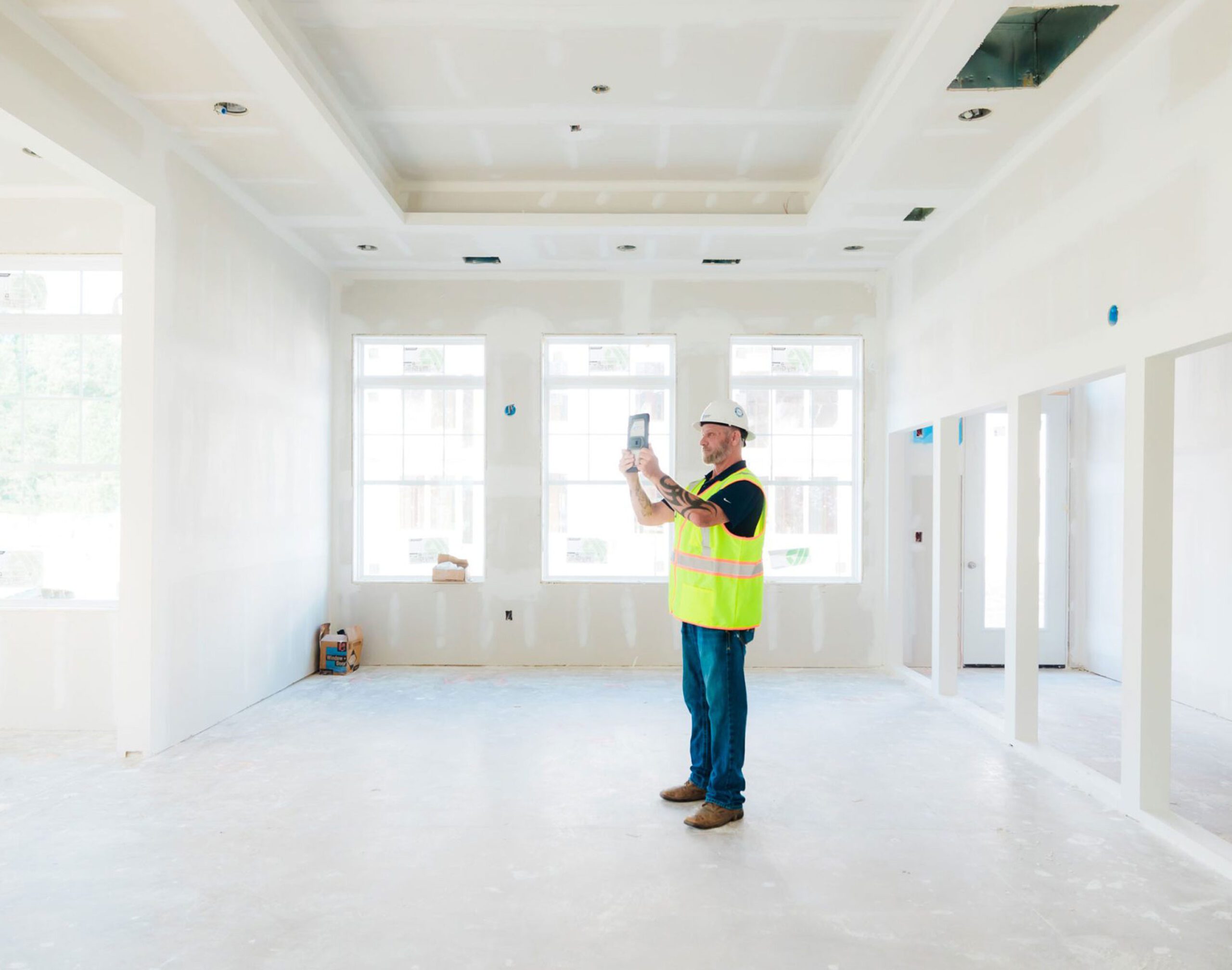 Construction worker taking photos of unfinished interior