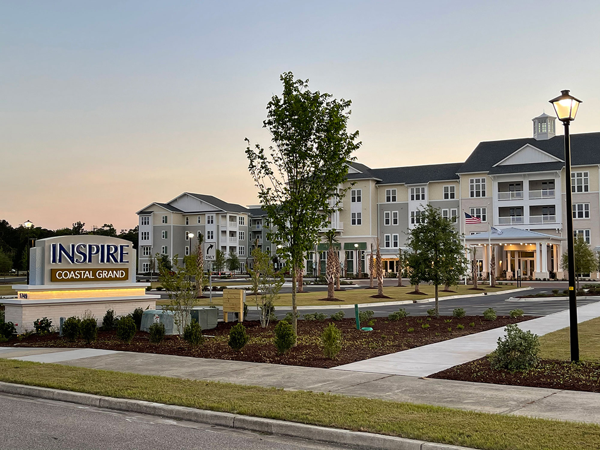 Inspire at Coastal Grand exterior: road-front signage + apartment complex