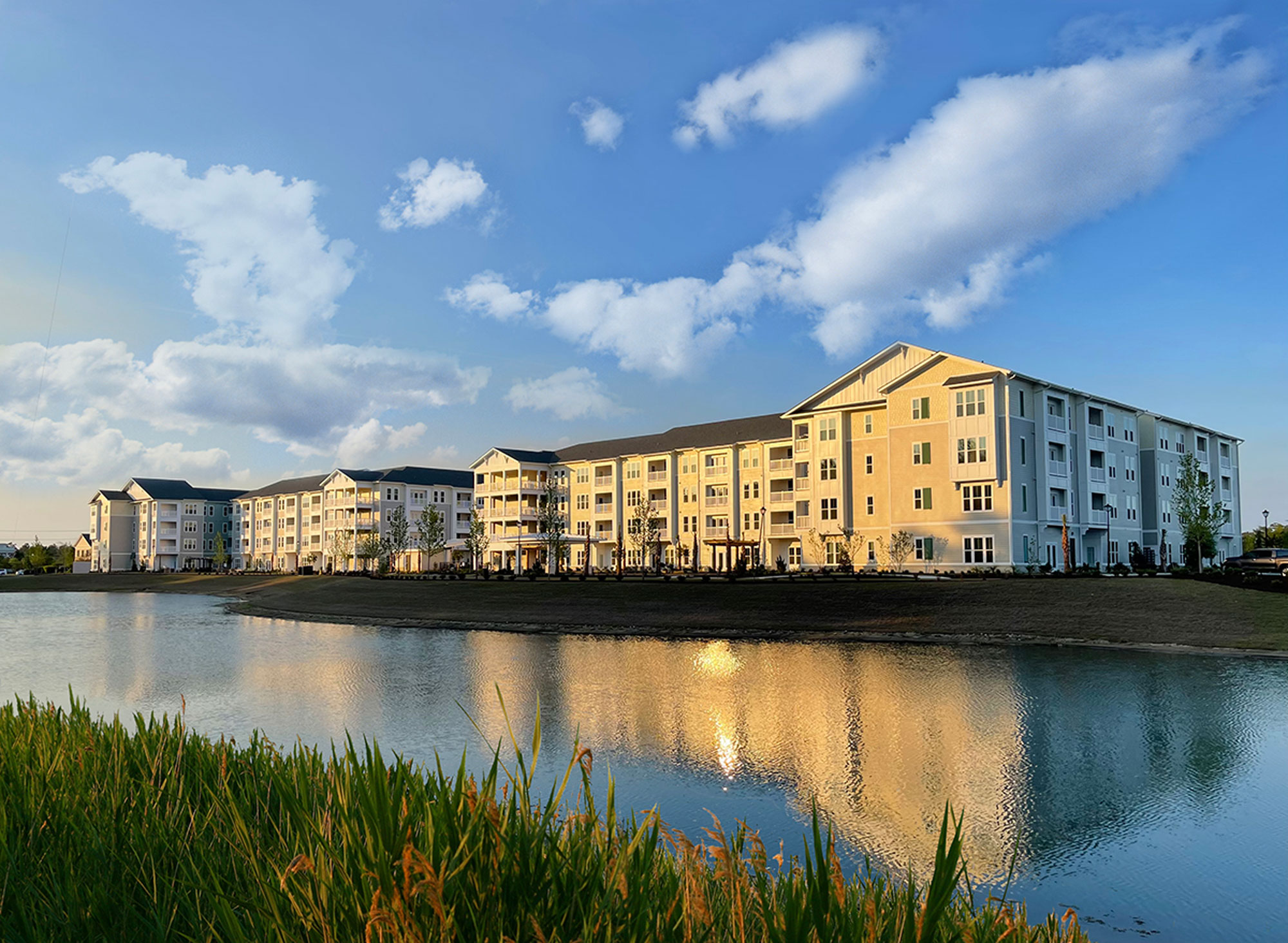 Inspire at Coastal Grand exterior: apartment complex overlooking waterway